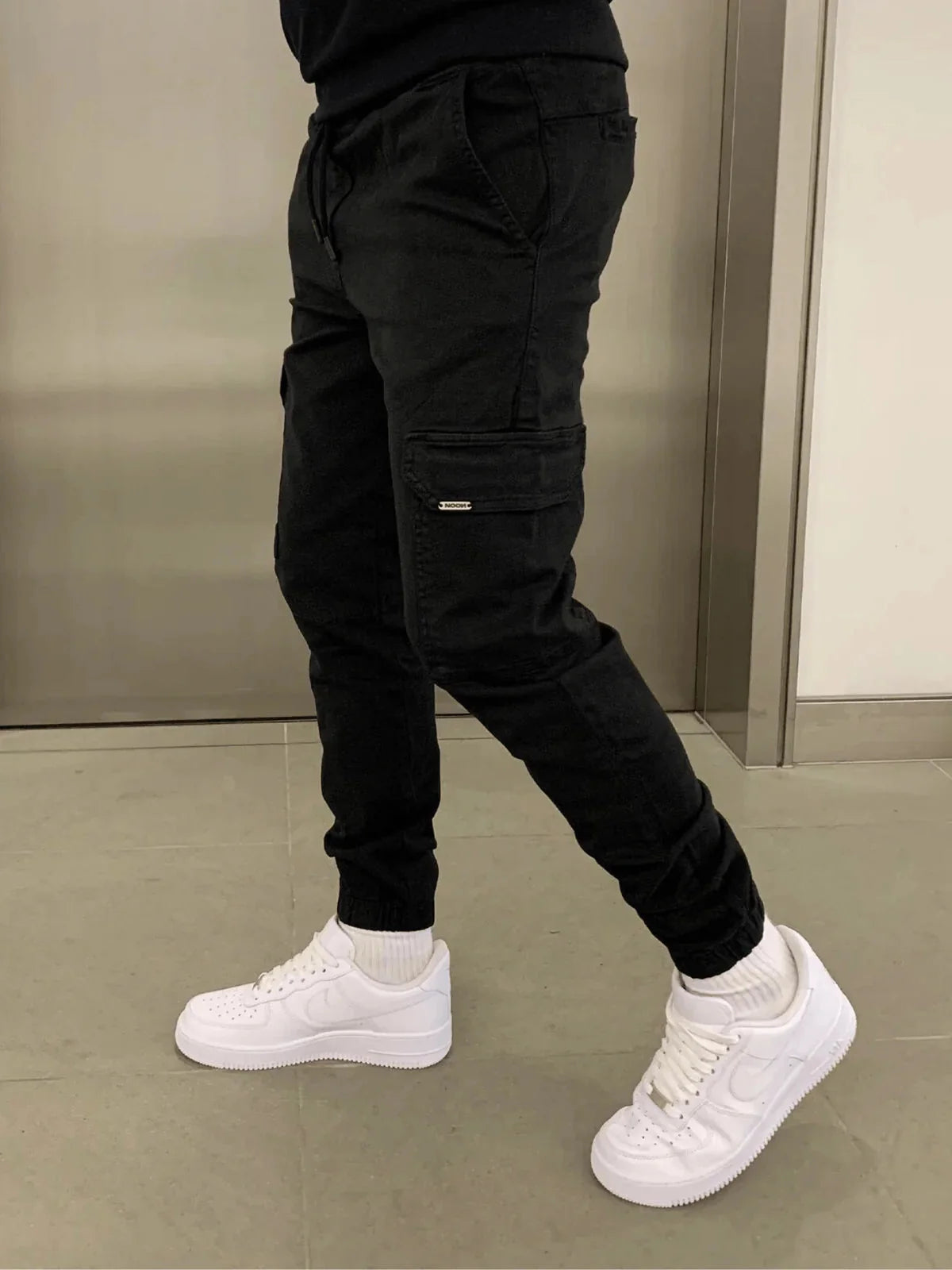 Black Men's Slim Fit Cargo Joggers with Drawstring Waist & Multi-Pocket Design — Harvey - Side Profile Walk