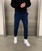 Navy Blue Men's Slim Fit Cargo Joggers with Drawstring Waist & Multi-Pocket Design — Harvey - Front Jump Pose